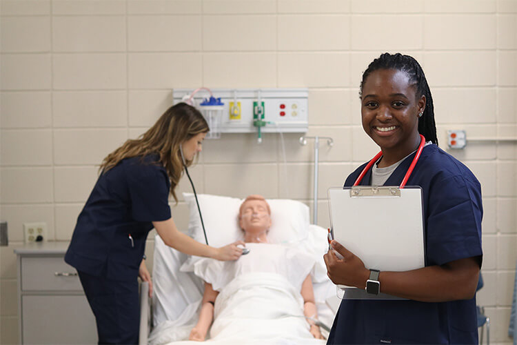 Nursing student smiling with clipboard